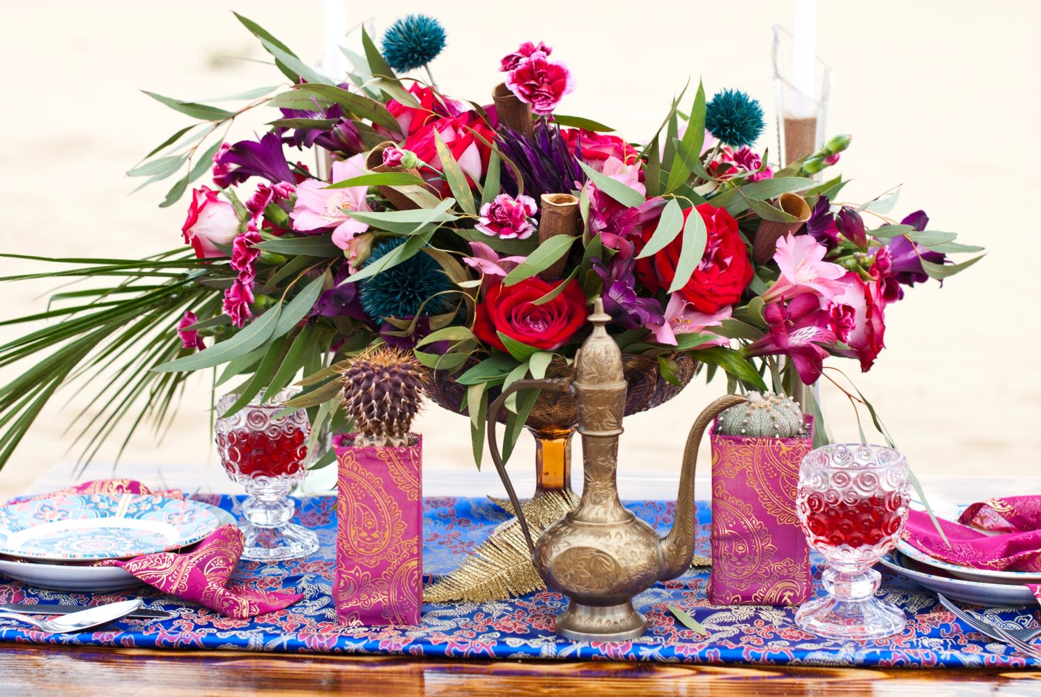Vibrant floral centerpiece with ornate decor on a colorful table setting.