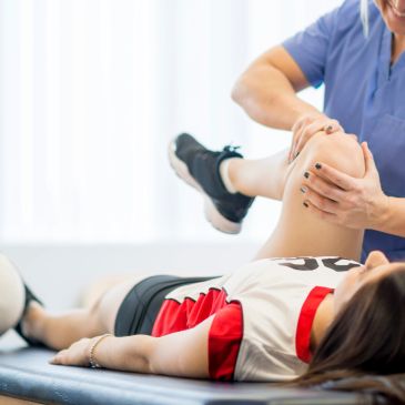 Fisioterapeuta trabajando en la rodilla de una paciente.
