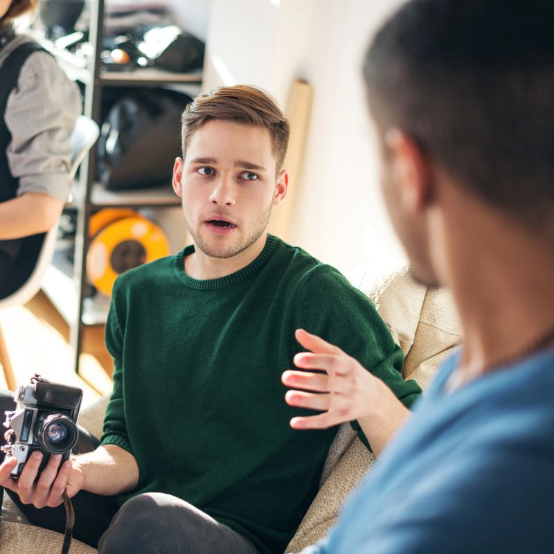 Two coworkers discussing about photography in a studio,