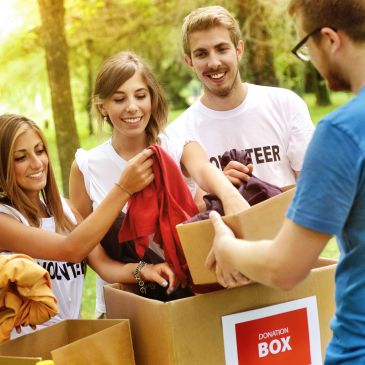 Volunteers donating clothes outdoors.