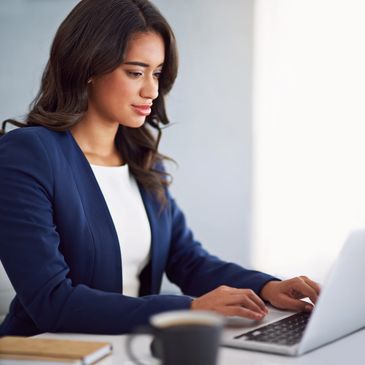 Professional woman working on a laptop in an office.