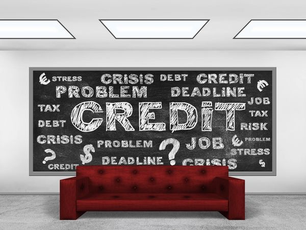 Blackboard with financial stress words above a red sofa.