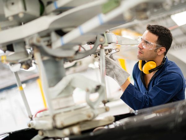 Aircraft technician inspecting complex engine components.