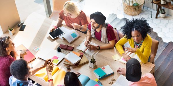 Educators and administrators collaborating and sharing experiences around a table
