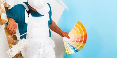 A man holding a color fan in his hand.