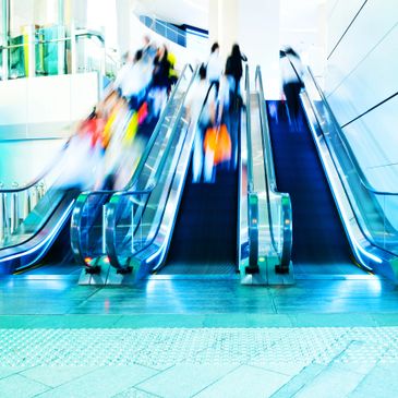 Blurred motion of people on escalators in a modern building.