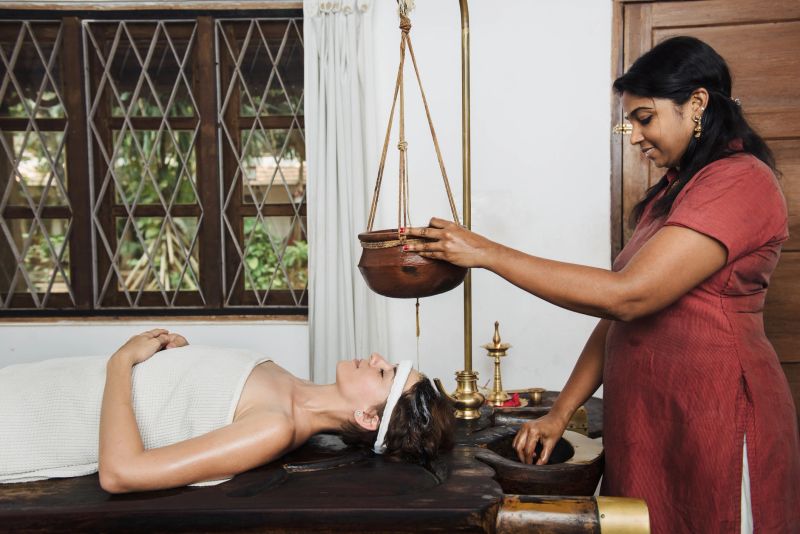 Caucasian woman having Ayurveda shirodhara treatment in India, Kerala state