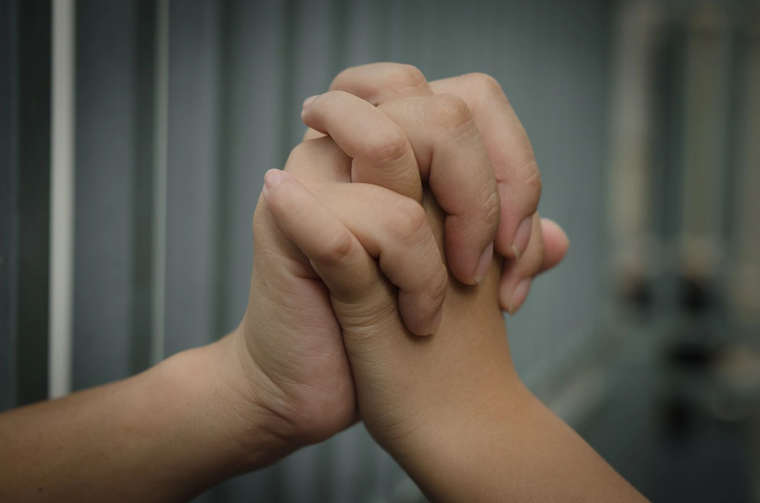 Two hands tightly clasped together in a gesture of unity or support.