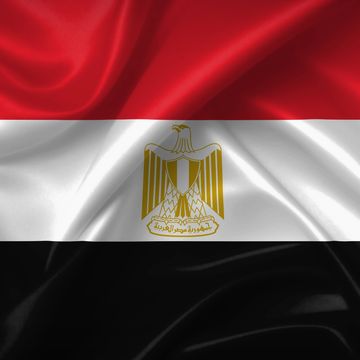 Waving flag of Egypt with the golden Eagle of Saladin emblem.