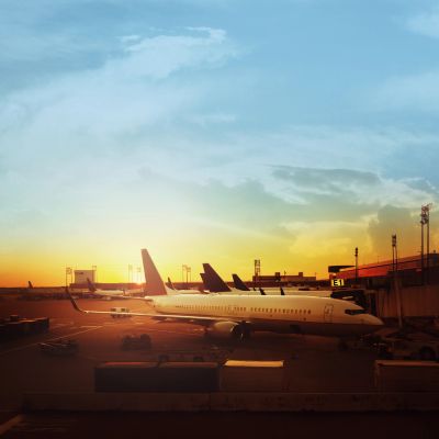 Airplanes parked at the airport during a vibrant sunset.