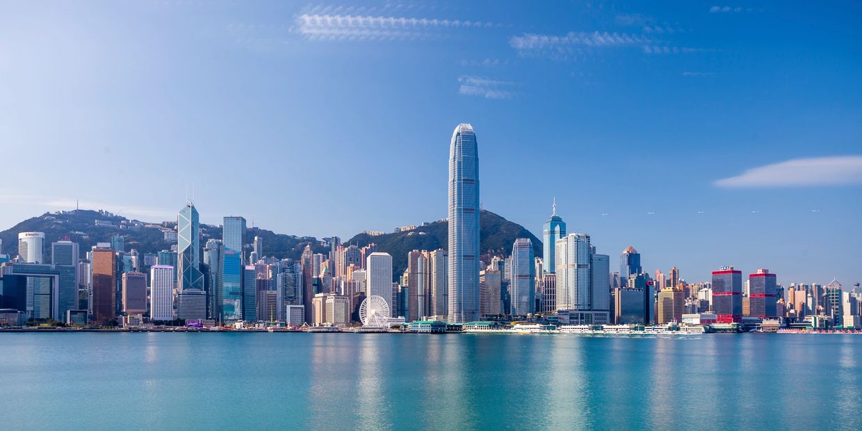 Skyline of Hong Kong with tall skyscrapers and clear blue sky.