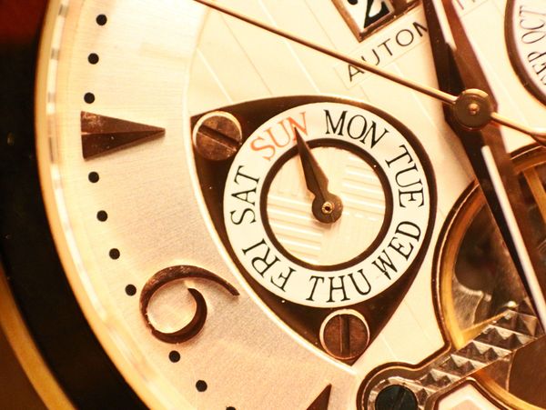Close-up of a luxury watch face showing days of the week.