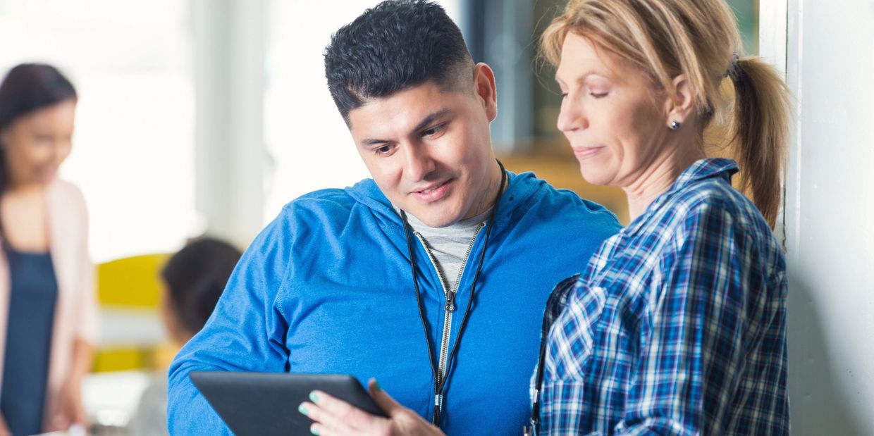Two adults looking at a tablet together in a casual setting.