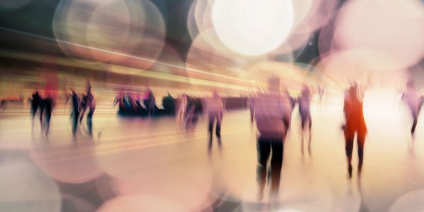 Blurred figures walking with large bokeh lights creating a dreamy effect.