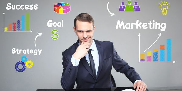 Businessman strategizing marketing and profit goals with graphs and teamwork concepts.