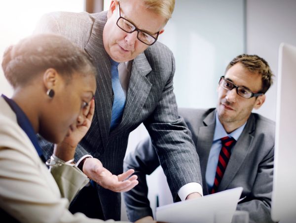 Businessman explaining documents to two colleagues in a meeting.