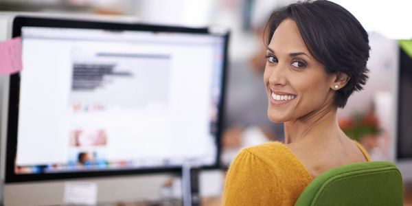 Woman smiling at her computer screen.