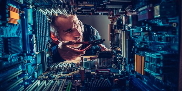 Technician repairing computer hardware inside.