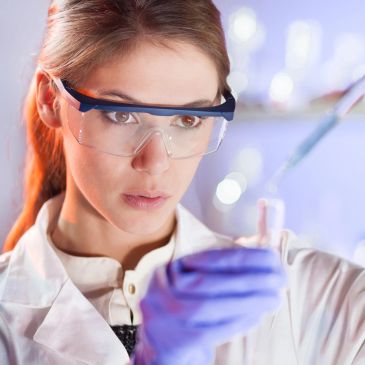 Female scientist working with test tubes in laboratory.