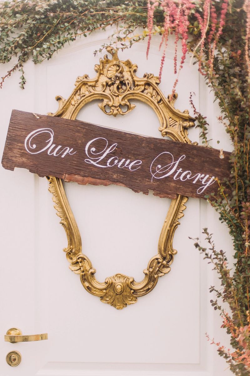 Wedding decorations. White vintage door with a sign Our love story on. Close up.