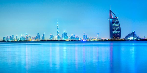 Bright skyline of Dubai with iconic Burj Al Arab at dusk.