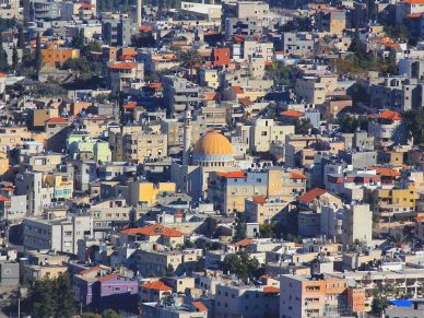 Vista de una ciudad con una mezquita de cúpula naranja.