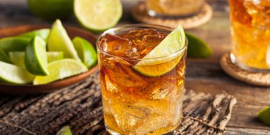 A refreshing iced drink garnished with a lime wedge on a rustic wooden table.