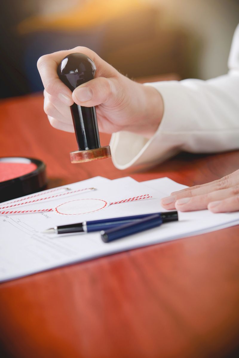 Woman Notary Public stamping the document. Law office.