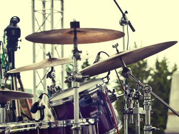 Close-up of a drum set in an outdoor setting.