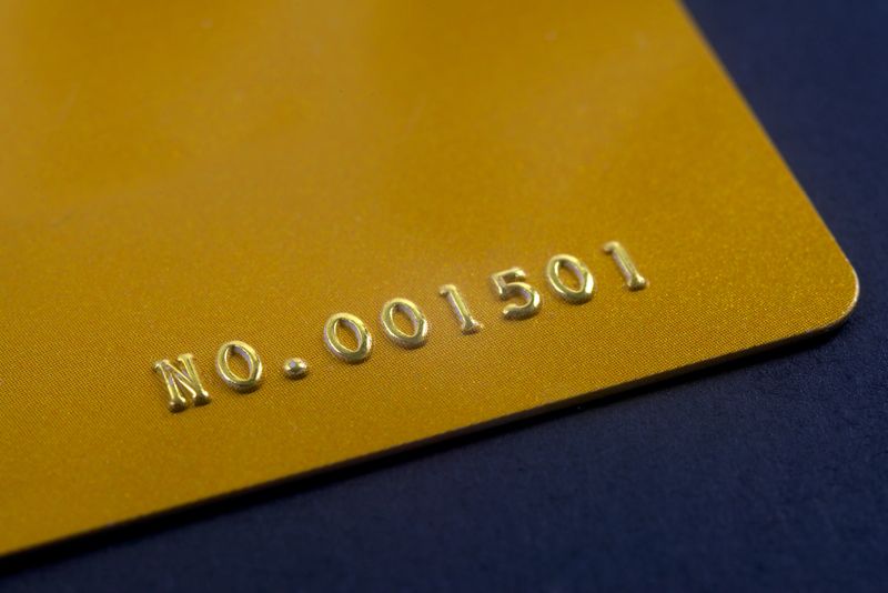 closeup golden credit card with embossed number