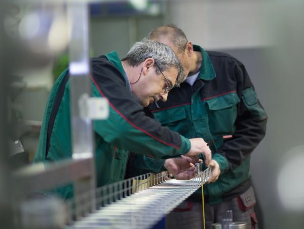 Two men working together on a technical project in a workshop.