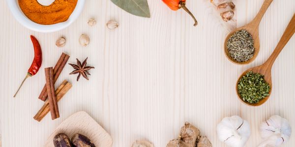 Various spices and herbs artistically arranged on a wooden surface.
