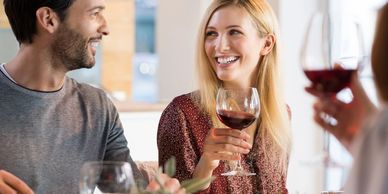 a man and a women smiling with wine