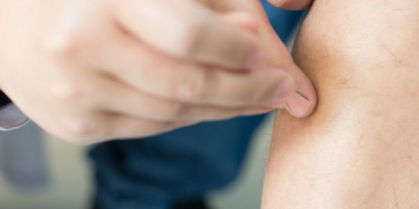A person flicking their finger on their arm.