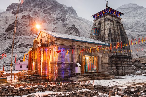 Snow-covered Kedarnath Temple decorated with lights in the Himalayas.