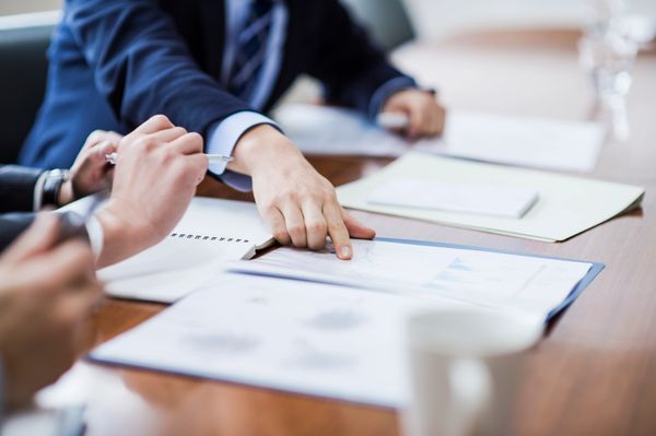 Business professionals reviewing documents and charts during a meeting.