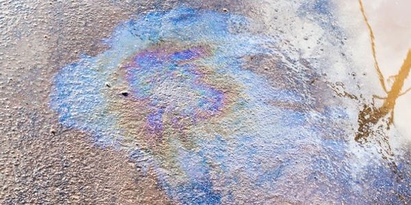 Oil spill creating colorful patterns on a wet surface.