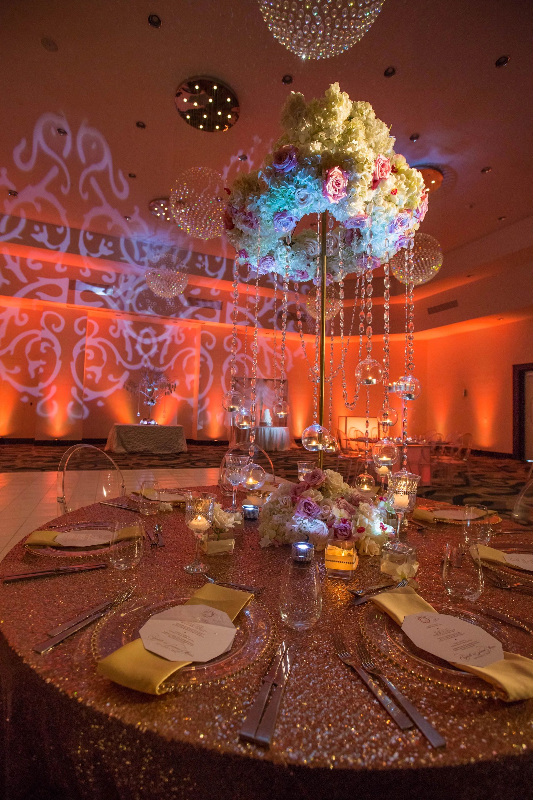 Elegant wedding table with floral centerpiece and warm lighting.