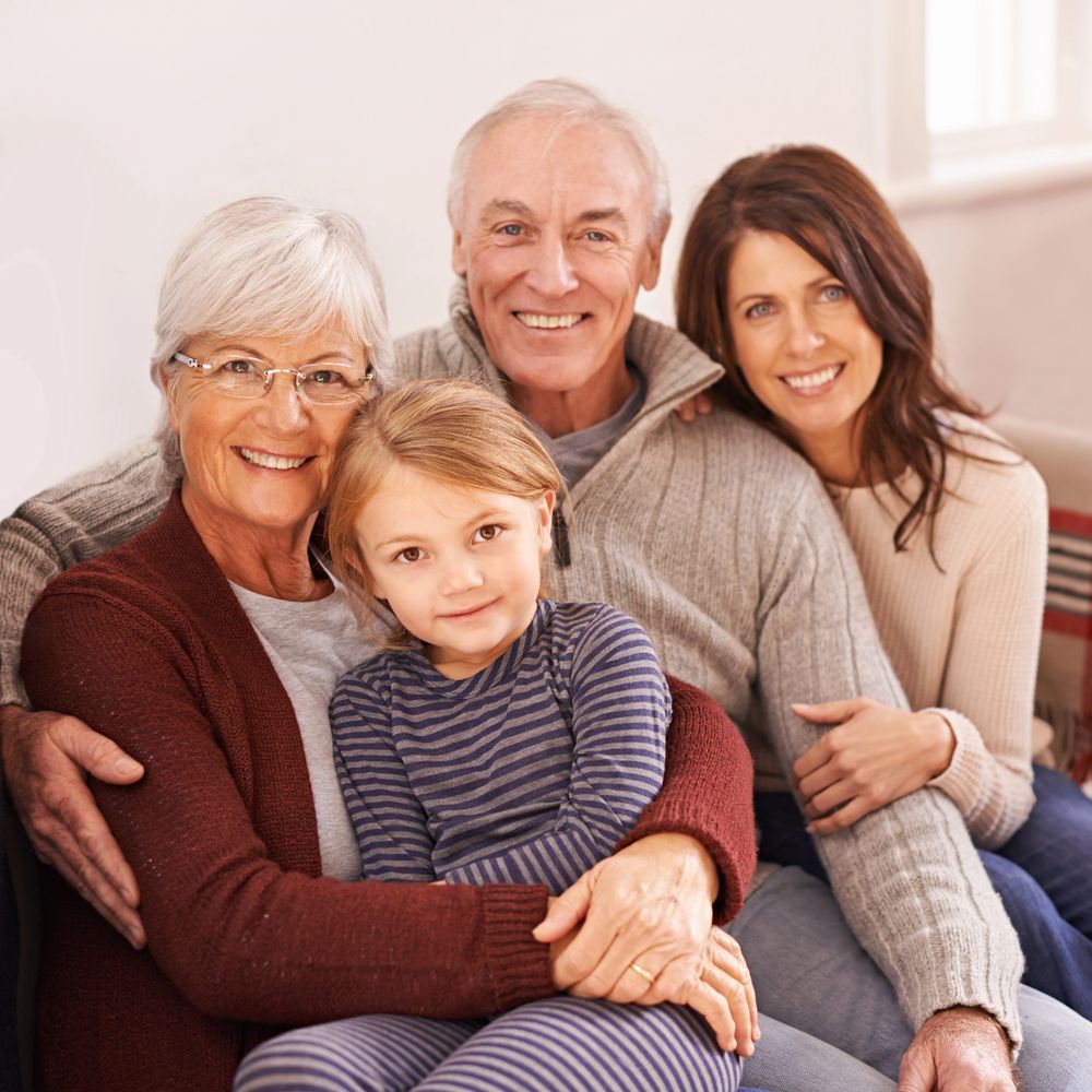 Happy multi-generational family smiling together on a cozy couch.