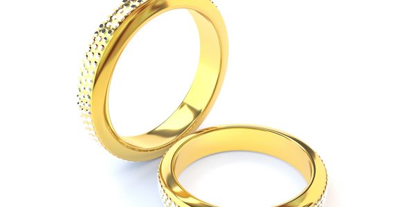 Two elegant gold rings with textured details on a white background.
