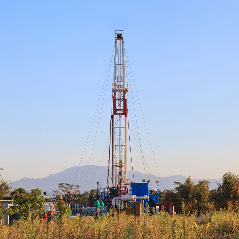 Oil Land Drilling Rig Working In The Field For Petroleum Exporation at Sunset Time