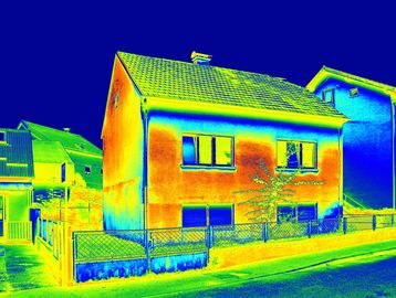 Thermal image showing heat distribution on a house and surroundings.