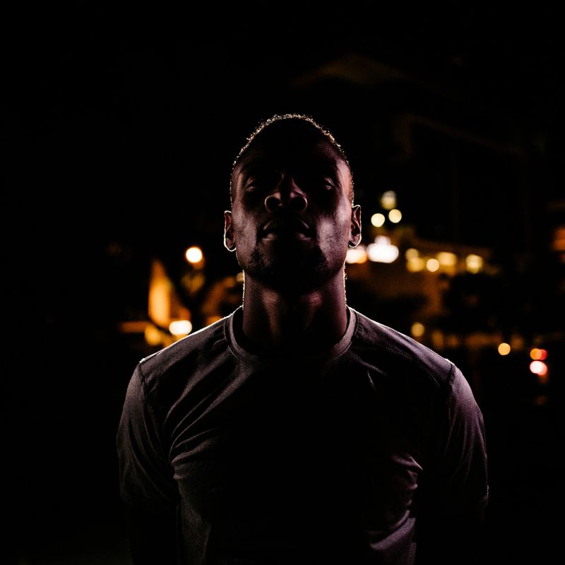 African American male basketball player with challenging face, ready to play a game of nighttime street ball