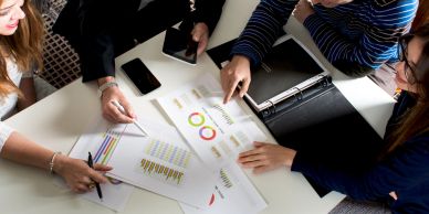 Team analyzing charts and graphs at a meeting.