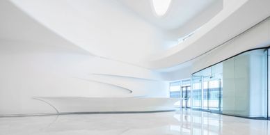 Sleek, futuristic white interior with smooth curves and reflective floors.