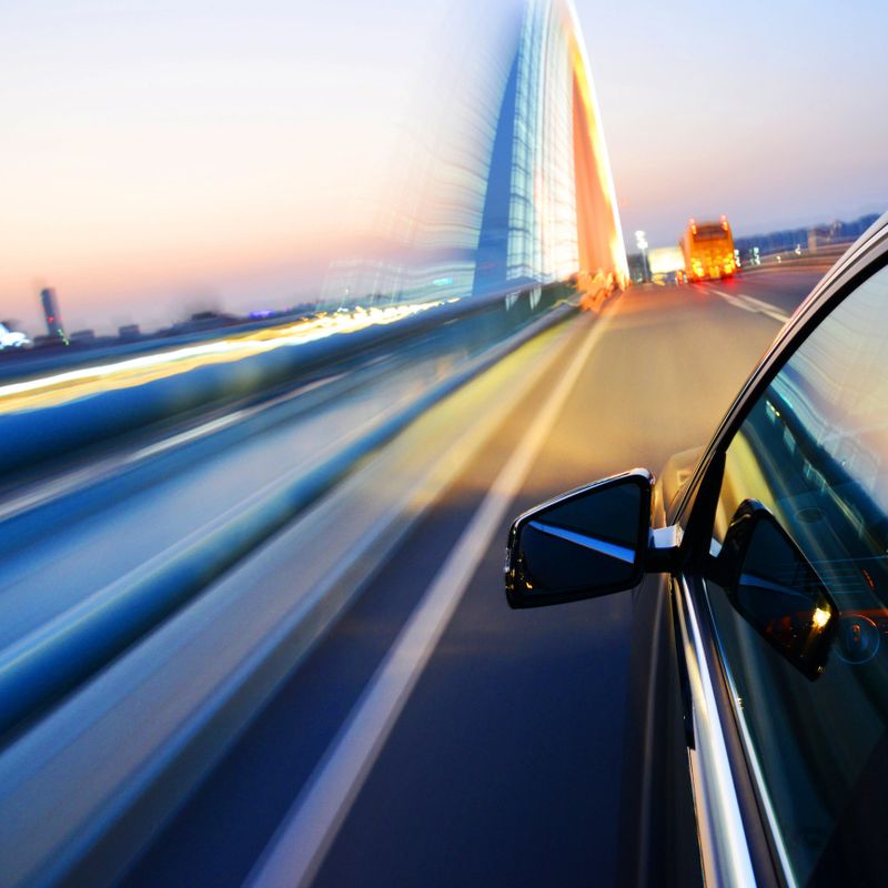 Car driving through the city at night.