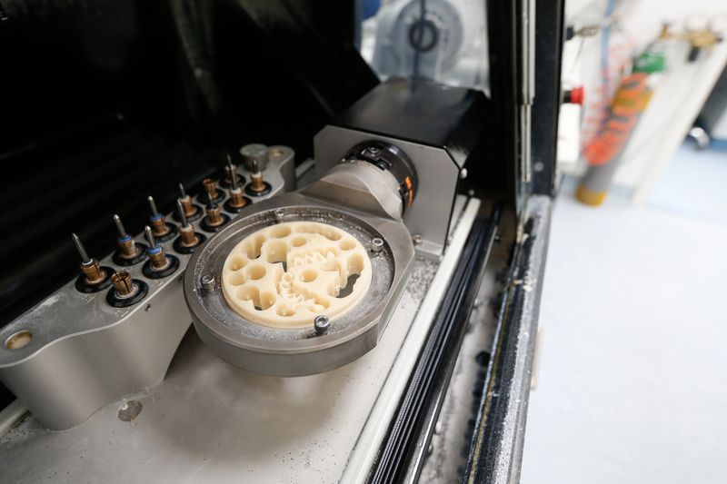 CAD/CAM dental machinery in a highly modern dental laboratory, with disc for protheses and crowns milling. Dentistry, prostodontics, prosthetic dentistry and computer aided machinery concept.