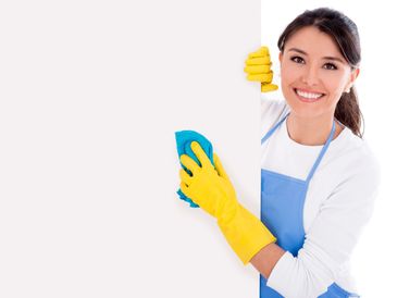 Smiling woman in yellow gloves cleaning a white surface with a blue cloth.
