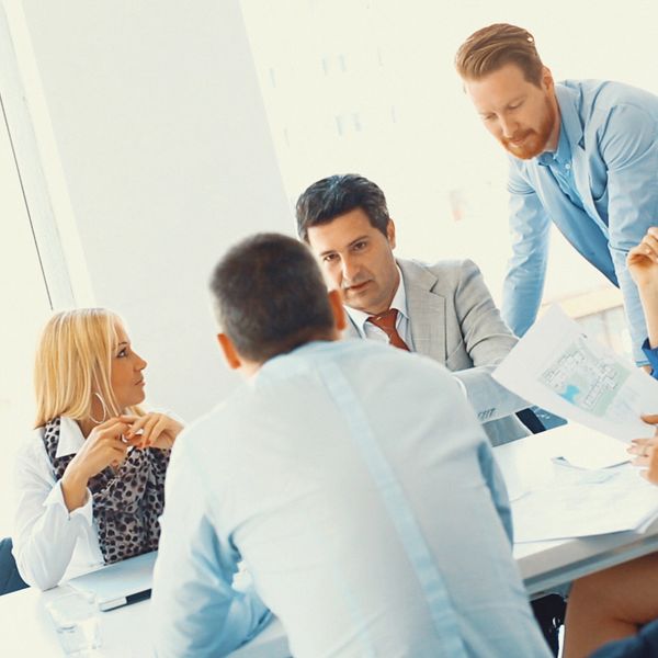 A group of professionals engaged in a business discussion around a table.