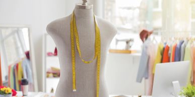 Tailor's mannequin with measuring tape in a bright workshop.